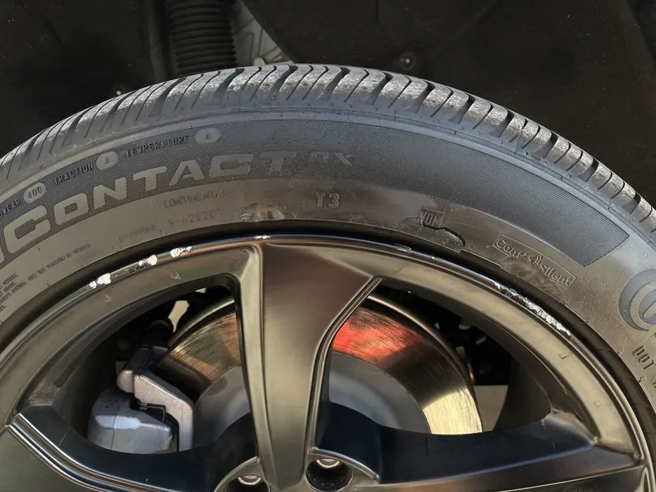 Tesla rim with curb rash before repair